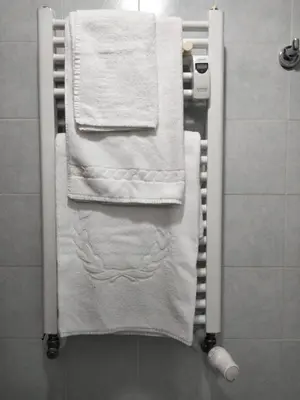 a towel rack with white towels on it in a bathroom at RIPOLI APARTMENT in Rome