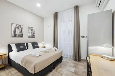 a bedroom with a bed and a desk and a window at Limehome Rome via dei Reti in Rome
