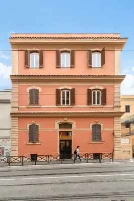 a person walking in front of a building at Limehome Rome via dei Reti in Rome