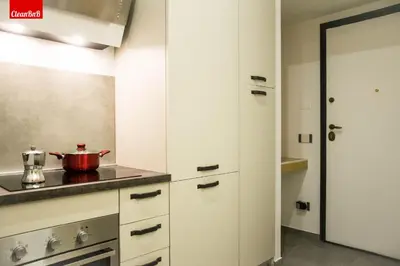 a kitchen with white cabinets and a pot on the counter at GuestHost - Largo Leopardi Modern Apartment in Rome