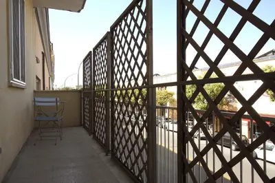 a balcony with a fence with a chair on it at Piramide Holiday House in Rome