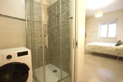 a shower with a glass door in a bathroom at Piramide Holiday House in Rome