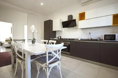 a kitchen with a table and chairs in a kitchen at Piramide Holiday House in Rome