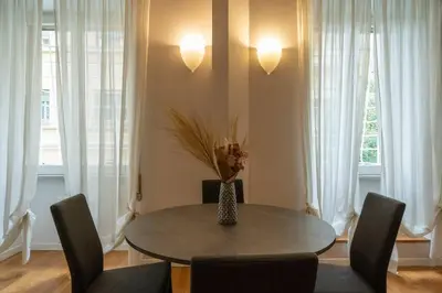 a dining room table with chairs and a vase with flowers at Vaticano vicino metro A-Comfort ed eleganza in Rome