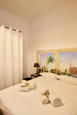 a bedroom with a bed with towels and a window at Vittorio Apartment Rome in Rome
