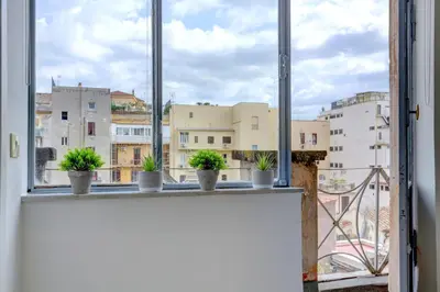 an open window with potted plants on a ledge at LOFT CAPOCCI 37 - Home and More in Rome