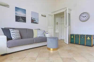 a living room with a couch and a clock on the wall at LOFT CAPOCCI 37 - Home and More in Rome