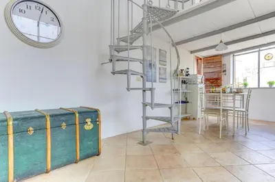 a room with a staircase and a clock on the wall at LOFT CAPOCCI 37 - Home and More in Rome