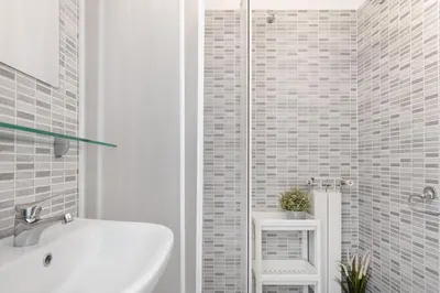 a white bathroom with a sink and a shower at central little basic apartment in Rome