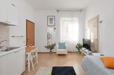 a kitchen and living room with white walls and wooden floors at central little basic apartment in Rome