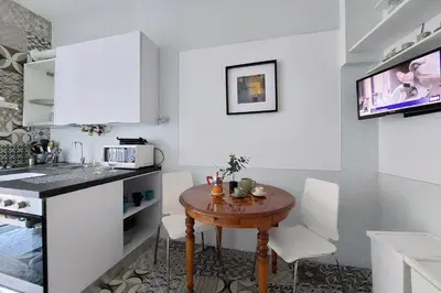 a small kitchen with a wooden table and white cabinets at Cozy Navona Flat in Rome