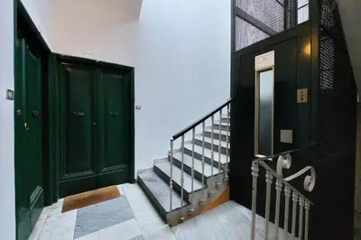 a hallway with two green doors and a staircase at Cozy Navona Flat in Rome