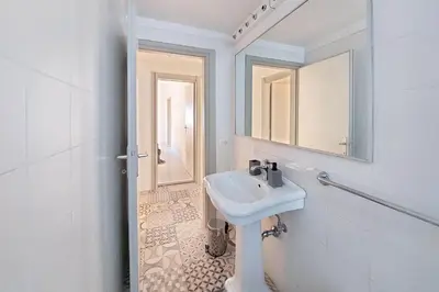 a white bathroom with a sink and a mirror at Cozy Navona Flat in Rome