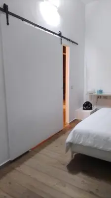 a bedroom with a bed and a white wall at GuestHost - Nel cuore di Trastevere Cozy Apartment in Rome