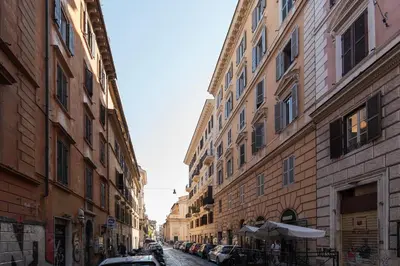 a narrow street with buildings in a city with cars at GuestHost - Nel cuore di Trastevere Cozy Apartment in Rome