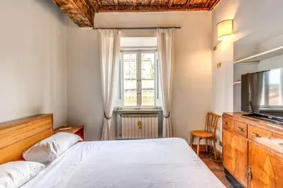 a bedroom with a bed and a tv and a window at Flat with Lovely Views near Piazza Navona in Rome