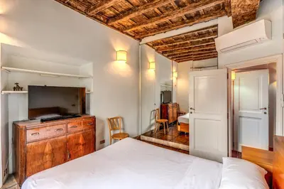 a bedroom with a bed and a dresser and a television at Flat with Lovely Views near Piazza Navona in Rome