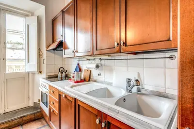 a kitchen with a sink and wooden cabinets at Flat with Lovely Views near Piazza Navona in Rome