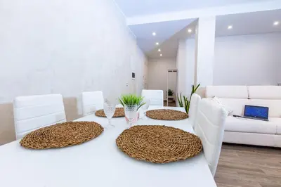 a dining room with a white table and white chairs at Noh Collection 2BDR apartment- Vatican Area in Rome