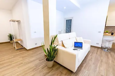 a white couch with a laptop on it in a living room at Noh Collection 2BDR apartment- Vatican Area in Rome