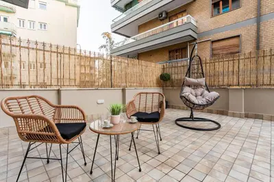 a patio with chairs and a table and a hammock at Noh Collection 2BDR apartment- Vatican Area in Rome