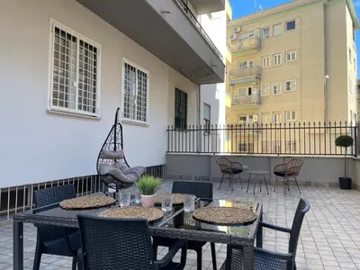 a patio with tables and chairs on a balcony at Noh Collection 2BDR apartment- Vatican Area in Rome