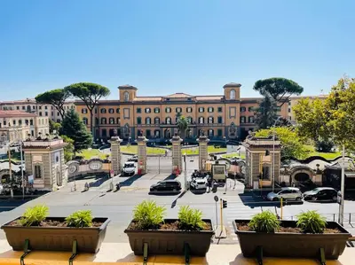 a large building with cars parked in a parking lot at Cozy apartment Gianicolense 3bdr in Rome
