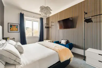 a bedroom with a bed and a tv on the wall at Cozy apartment Gianicolense 3bdr in Rome
