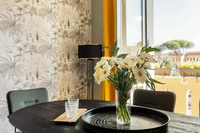 a table with a vase of flowers on it at Cozy apartment Gianicolense 3bdr in Rome