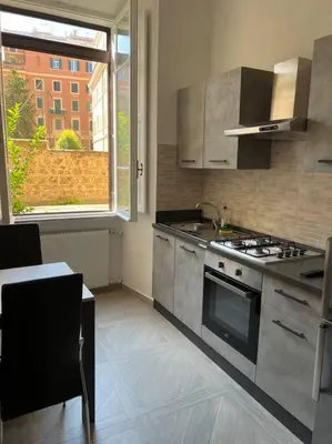 a kitchen with a stove and a sink and a window at Sant'Angelo House in Rome