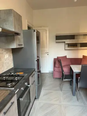 a kitchen with a stove and a table and a couch at Sant'Angelo House in Rome