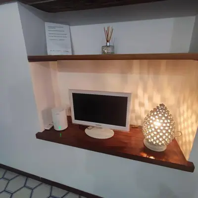 a computer monitor sitting on a wooden shelf at Casa Claudia ~ rione Monti-Colosseo in Rome