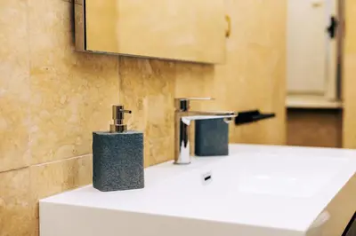 a bathroom with two faucets on a white sink at Elegant oasis among the Vatican and Via del Corso in Rome
