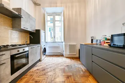 a kitchen with a wooden floor and a counter top at Elegant oasis among the Vatican and Via del Corso in Rome