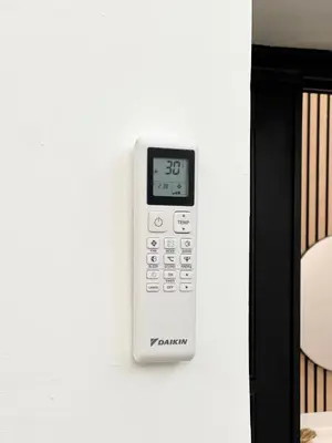 an electronic thermometer on a wall next to a bed at Avocado House - Cozy Apartment in the Heart of Rome in Rome