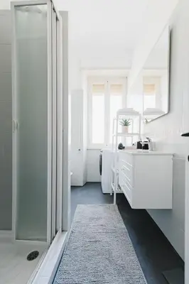 a white bathroom with a sink and a mirror at Casa Boccea 112 in Rome