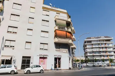 a tall white building with cars parked in front of it at Casa Boccea 112 in Rome