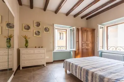 a bedroom with a bed and a dresser and windows at Frangipane 31 Monti Terrace in Rome