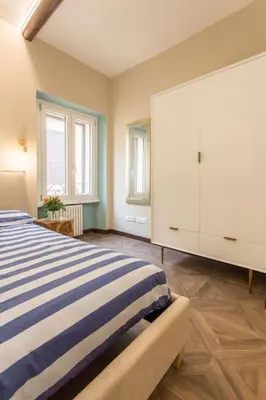 a bedroom with a blue and white bed and two windows at Frangipane 31 Monti Terrace in Rome