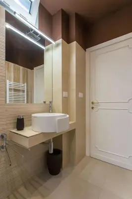 a bathroom with a sink and a mirror and a door at Frangipane 31 Monti Terrace in Rome