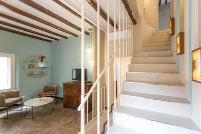 a staircase in a living room with a table and chairs at Frangipane 31 Monti Terrace in Rome