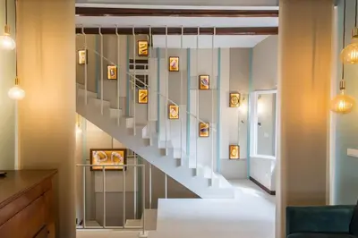 a staircase in a living room with pictures on the wall at Frangipane 31 Monti Terrace in Rome
