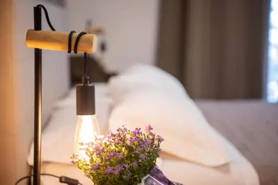 a lamp with flowers on a table next to a bed at Vatican Fashion Home in Rome