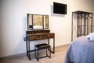 a bedroom with a dresser with a mirror and a stool at Vatican Fashion Home in Rome