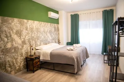 a bedroom with a bed and a green wall at Vatican Fashion Home in Rome