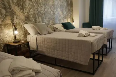 a room with three beds with towels on them at Vatican Fashion Home in Rome