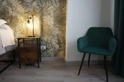 a bedroom with a green chair next to a bed at Vatican Fashion Home in Rome