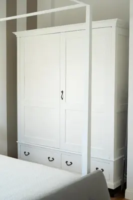 a bedroom with a white bed and a white dresser at Casa Mirabella in Rome