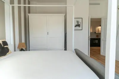 a bedroom with a white bed and a closet at Casa Mirabella in Rome