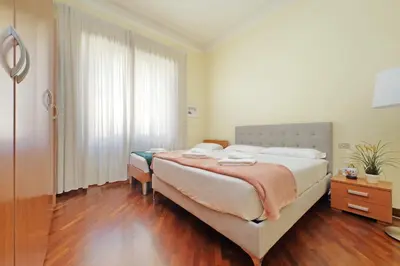 a bedroom with two beds and a large window at 4BNB - Cimabue Apartment in Rome